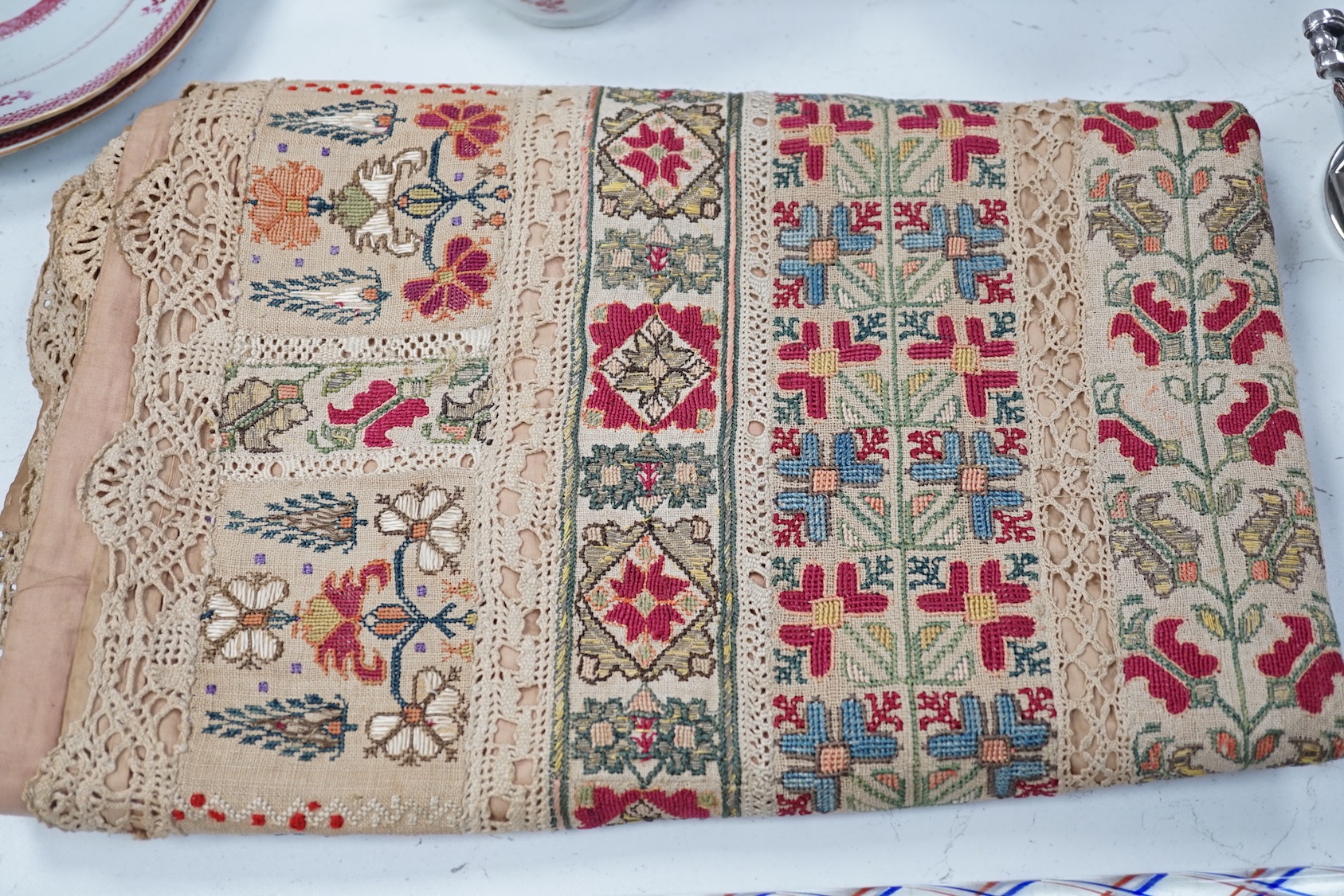 A 19th century Greek Islands polychrome silk embroidered runner on cram linen, with silk and linen bobbin lace insertions and edging. Backed with a mushroom satin lining, 190 cms long x 84 cms wide.